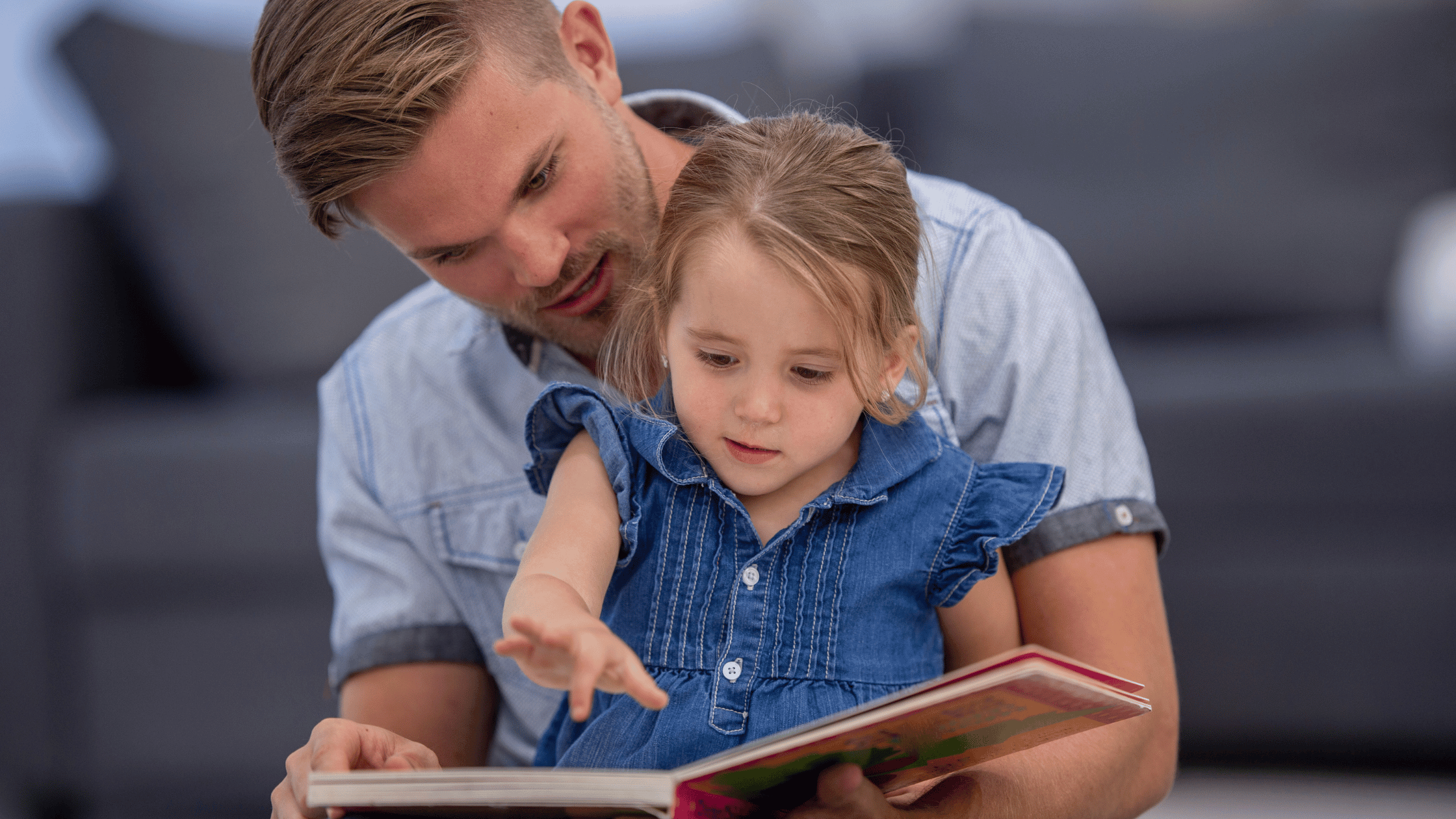 child with father reading a book in French
